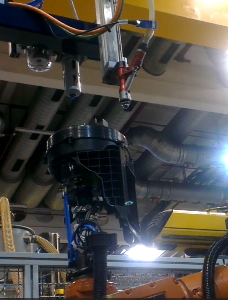 Roboter hält Bauteil unter Schraubautomat